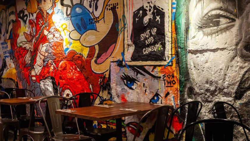 Interior moderno del restaurante Garua Bar en San Sebastián, con decoración de graffitis, iluminación cálida y ambiente acogedor
