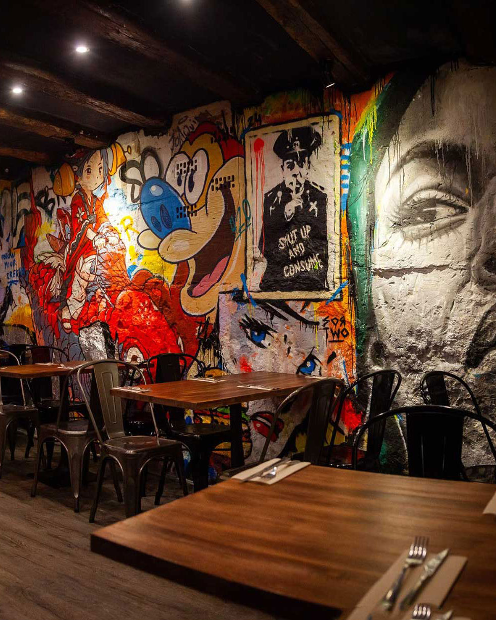 Interior moderno del restaurante Garua Bar en San Sebastián, con decoración de graffitis, iluminación cálida y ambiente acogedor