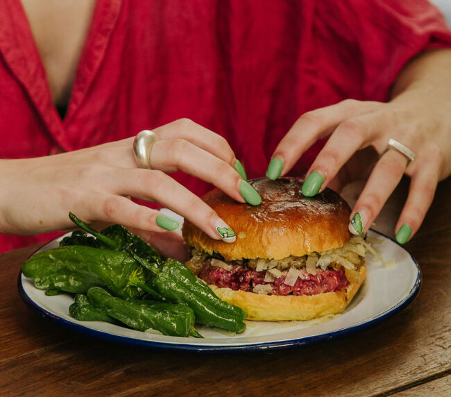 Hamburguesa Basque Country Garua con 180 g de carne de txuleta jugosa, queso Idiazabal fundido, cebolla pochada, pimientos de Padrón y patatas, en Garua Bar de Donostia-San Sebastián