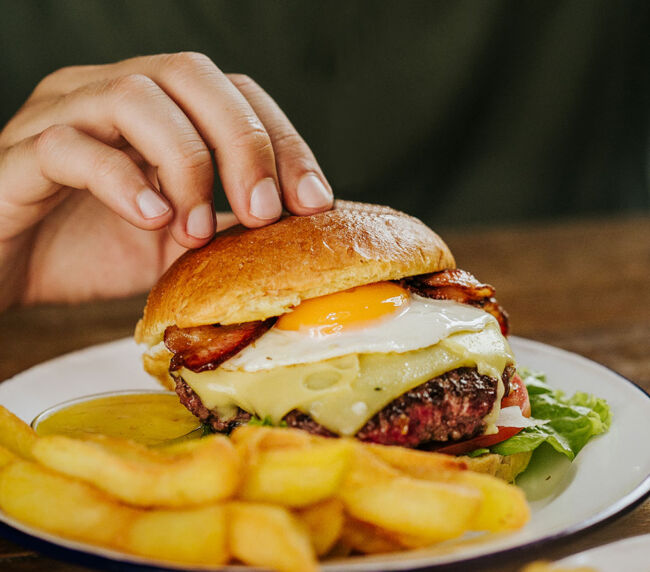 Hamburguesa completa Garua bar con carne de chuleta, queso, lechuga, bacon, huevo frito, tomate y salsa, en la hamburguesería Garúa Bar de Donostia-San Sebastián