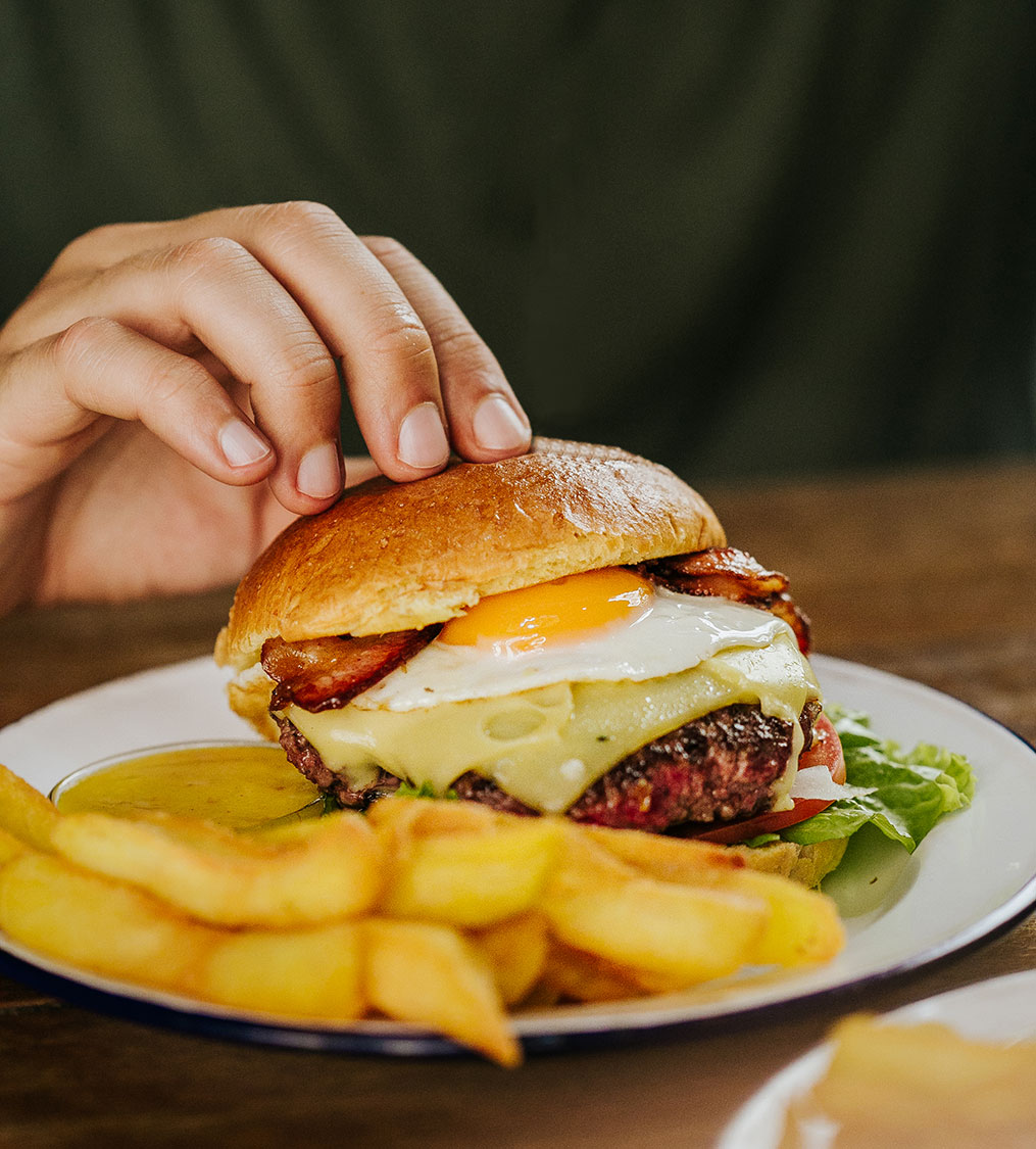 Hamburguesa completa Garua bar con carne de chuleta, queso, lechuga, bacon, huevo frito, tomate y salsa, en la hamburguesería Garúa Bar de Donostia-San Sebastián