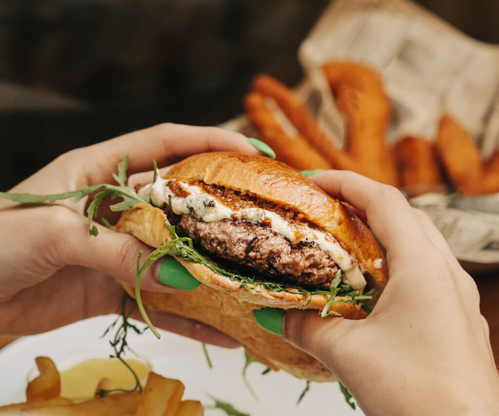 Hamburguesa roquefort Garua con carne de chuleta, queso roquefort fundido, tomate seco y rúcula fresca acompañada de unas deliciosas patatas fritas en la hamburguesería Garúa Bar de Donostia-San Sebastián